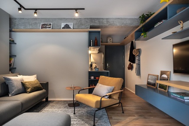 
Phòng khách với màu xanh và xám, đồ nội thất bọc da và có đèn, kết hợp không gian văn phòng tại nhà.
