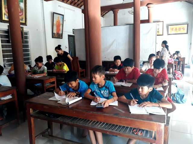 Tấm bảng đơn sơ làm vạch ngăn, phân chia 2 lớp học