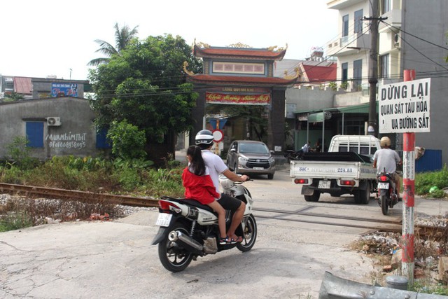 Tại điểm giao cắt đường sắt dẫn vào cổng thôn Quỳnh Khê - Nơi xảy ra vụ tai nạn có biển cảnh báo chú ý quan sát tàu hỏa. Ảnh: Đ.Tùy