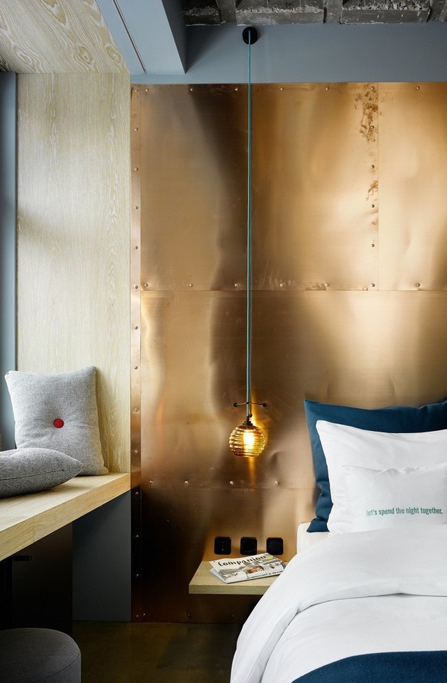 
Pha trộn màu sắc lạnh và ấm là một ý tưởng hoàn hảo. Ở đây một bức tường đồng được kết hợp với bộ đồ giường bằng ngọc lục bảo và gối màu xám.
