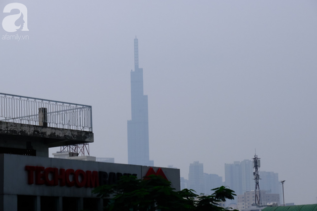 TP.HCM từ sáng đến chiều mịt mù khói sương, người dân đeo khẩu trang, trùm kín mít khi ra đường vì sợ ô nhiễm - Ảnh 1.