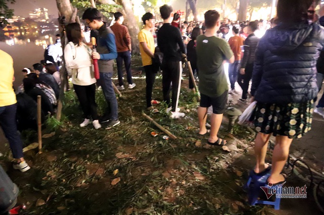 Bất chấp người cầm gậy xua đuổi, hoa hồ Gươm vẫn tan t&aacute;c sau giao thừa - Ảnh 8.