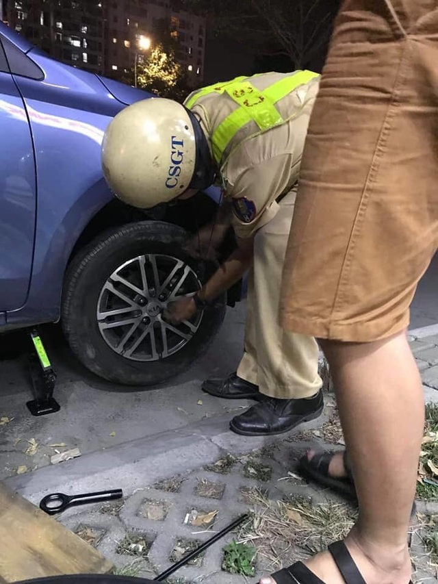 Ô tô bể bánh loạng choạng, CSGT Sài Gòn giúp tài xế thay lốp xe - Ảnh 2.