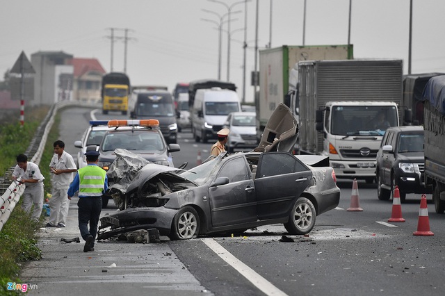 Tài xế thoát chết, chiếc Toyota Camry vỡ nát sau khi tông xe tải - Ảnh 1.