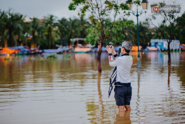 Chùm ảnh: Hội An vẫn đẹp với những nụ cười lạc quan của người dân dù nước lũ đang bao trùm phố cổ - Ảnh 6.