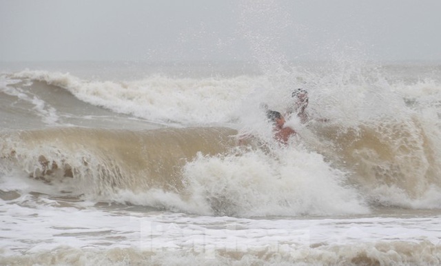 Biển động sóng cao phủ đầu, người dân Đà Nẵng vẫn liều mình tắm biển sau bão - Ảnh 4.