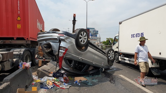 Xe container tông ô tô lật ngửa trên cầu vượt ở Sài Gòn - Ảnh 1.