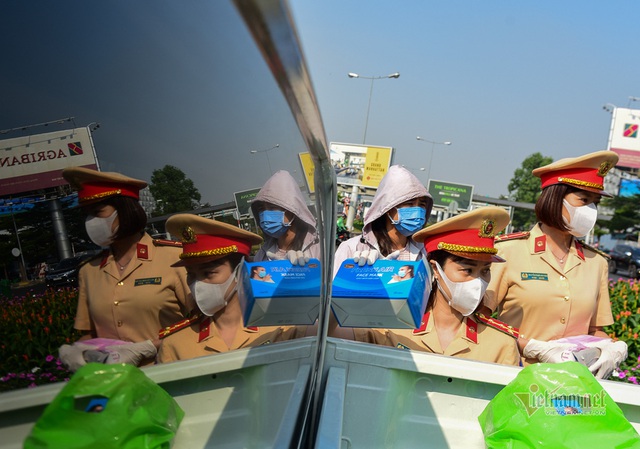 Nữ cảnh sát đội nắng phát khẩu trang ở cửa ngõ Tân Sơn Nhất - Ảnh 4.
