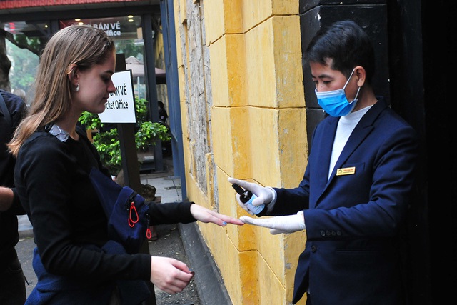 Hà Nội: Phát khẩu trang, xịt nước rửa tay kháng khuẩn cho du khách - Ảnh 5.