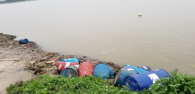Truy tìm chiếc xe tải đổ trộm nhiều thùng phuy nghi chứa chất độc hại xuống sông Hồng - Ảnh 1.