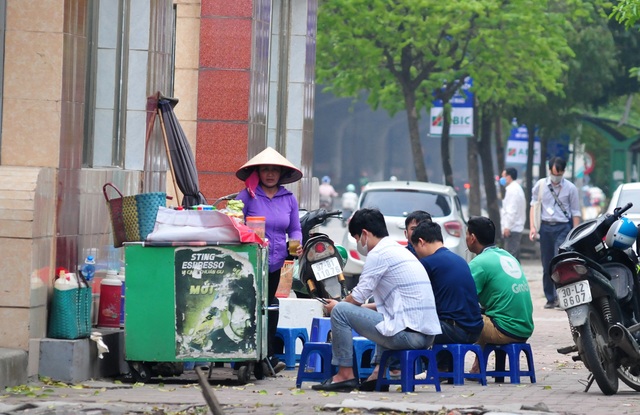 Nguy cơ COVID-19 đang cận kề nhưng nhiều người Hà Nội vẫn giữ thói quen túm năm tụm ba quán nước vỉa hè  - Ảnh 1.