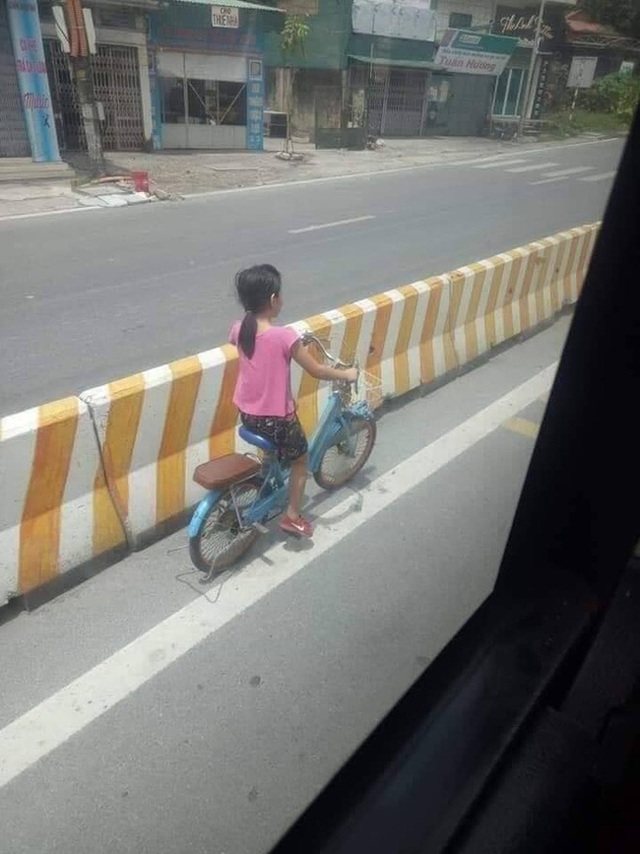 Bé gái đi xe đạp bị kẹt ở dải phân cách không thể sang đường, tài xế xe khách đã có hành động đặc biệt - Ảnh 1.