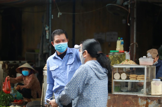 Cận cảnh kiểm soát thân nhiệt, tets nhanh COVID-19 người dân ra vào chợ đầu mối, chợ dân sinh tại Hà Nội  - Ảnh 9.
