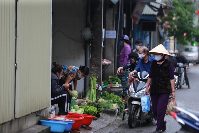 Cận cảnh kiểm soát thân nhiệt, tets nhanh COVID-19 người dân ra vào chợ đầu mối, chợ dân sinh tại Hà Nội  - Ảnh 11.