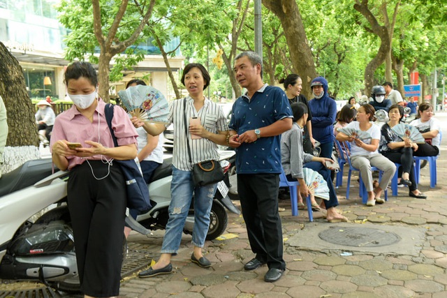 Cha mẹ “đội nắng” ngóng chờ bên ngoài trường thi vào lớp 10 - Ảnh 4.