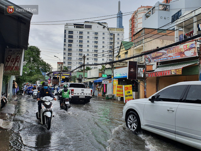 TP.HCM: S&aacute;ng nắng gắt, chiều mưa lớn kinh ho&agrave;ng khiến người d&acirc;n ướt sũng, b&igrave; b&otilde;m dắt xe lội nước - Ảnh 20.