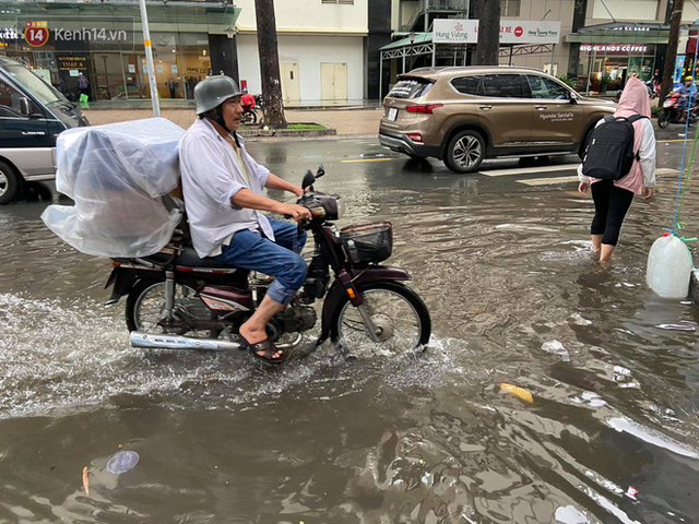 TP.HCM: S&aacute;ng nắng gắt, chiều mưa lớn kinh ho&agrave;ng khiến người d&acirc;n ướt sũng, b&igrave; b&otilde;m dắt xe lội nước - Ảnh 21.