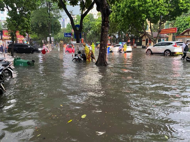 Hà Nội: Mưa to như trút nước lúc tan tầm, nhiều tuyến phố trung tâm lại biến thành sông - Ảnh 2.