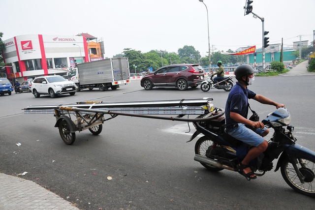 Tái diễn tình trạng chuyên chở các vật liệu sắc nhọn cồng kềnh trên đường phố Hà Nội - Ảnh 1.