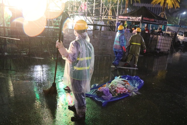 Xúc động hình ảnh những người lao công dầm mình giữa mưa thu dọn rác sau countdown - Ảnh 1.