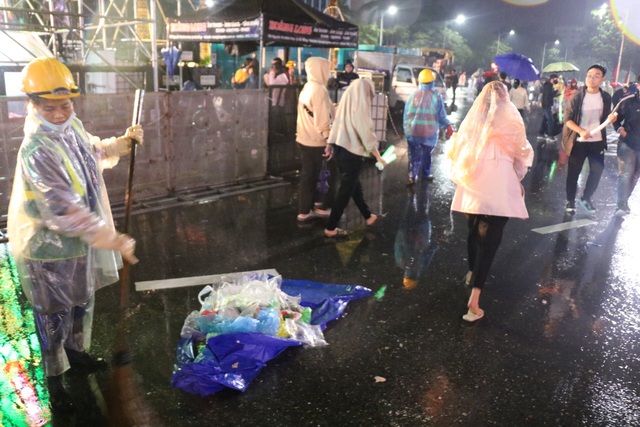 Xúc động hình ảnh những người lao công dầm mình giữa mưa thu dọn rác sau countdown - Ảnh 6.