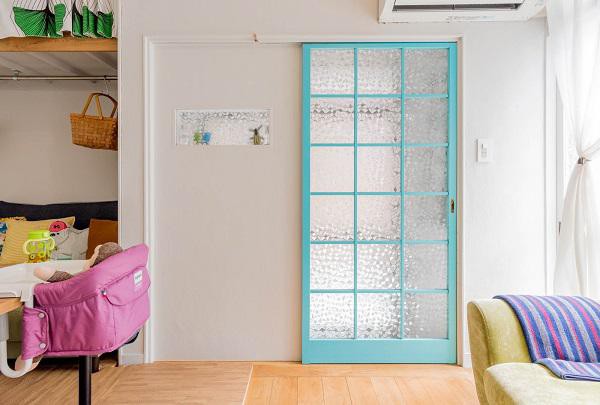 Chiếc cửa xanh xinh xắn hài hòa với các vật dụng xung quanh dẫn vào ngôi nhà của vợ chồng trẻ.