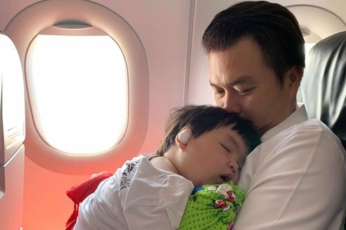 Con trai Lê Khánh ngủ trên vai bố trong lần đầu đi máy bay