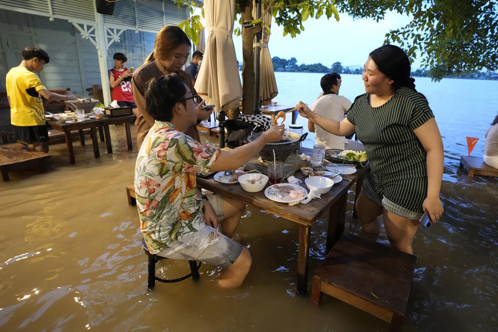 Lụt lội dâng đến bắp chân, người dân vẫn kéo nhau ra ngồi ăn lẩu - Ảnh 1.