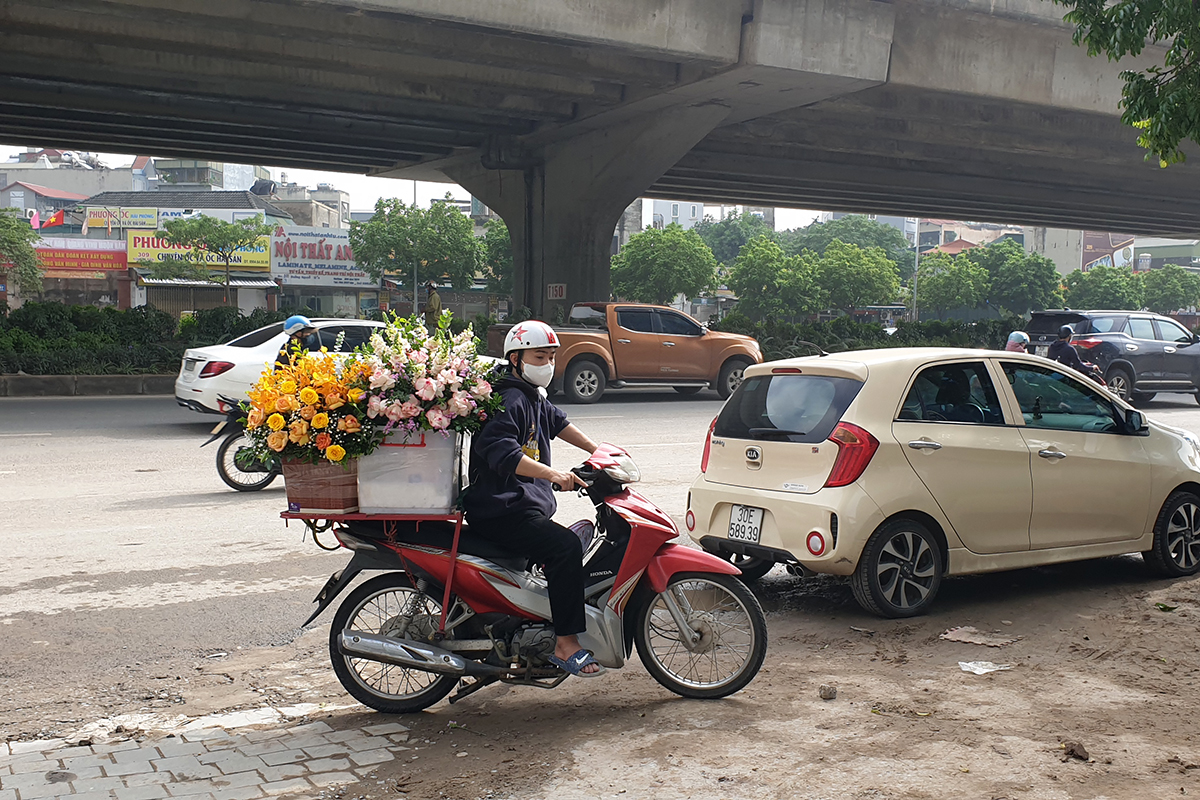 Shipper hoa tất bật khắp đường phố trong ngày Phụ nữ Việt Nam - Ảnh 1.