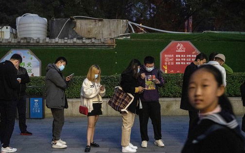 Bắc Kinh náo loạn, các bậc phụ huynh ôm chăn, gối đứng trước cổng khi Covid-19 tấn công trường học - Ảnh 1.