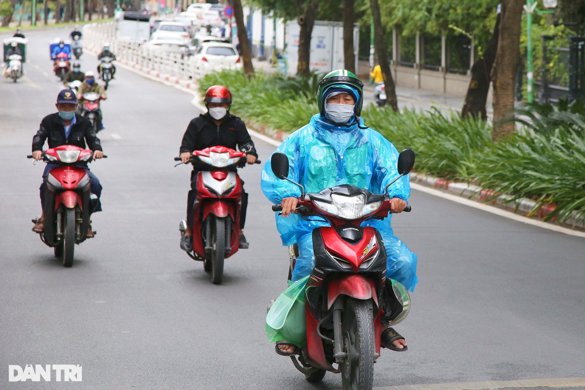 Hà Nội rét đậm, người ra đường phải nép sát nhau, mặc áo mưa tránh gió lạnh - Ảnh 1.