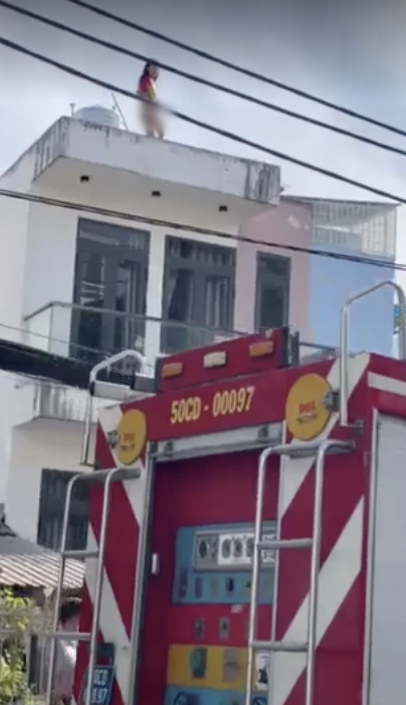 TP.HCM: Cô gái trẻ thoát y trên nóc nhà la hét, định nhảy xuống đất tự tử - Ảnh 1. TP.HCM: Cô gái trẻ thoát y trên nóc nhà la hét, định nhảy xuống đất tự tử - Ảnh 1.