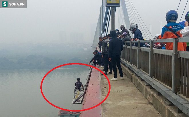 Trăm người thót tim dõi theo màn giải cứu thanh niên vắt vẻo trên lan can cầu Nhật Tân - Ảnh 1.