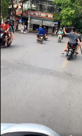 Kinh hãi 2 thiếu niên đi xe đạp điện ngổ ngáo cầm hung khí dọa đánh người giữa đường phố Hà Nội - Ảnh 1.