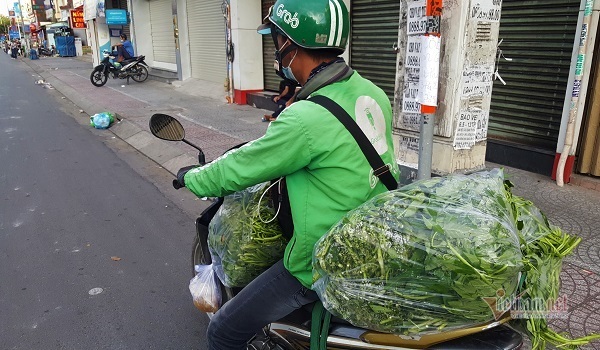 Những chàng trai trẻ, tay xách nách mang lượn khắp phố Sài Gòn vắng lạ - Ảnh 2.