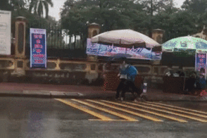 Xúc động clip nữ tình nguyện viên chạy hộc tốc che mưa cho thí sinh đi muộn - Ảnh 1.