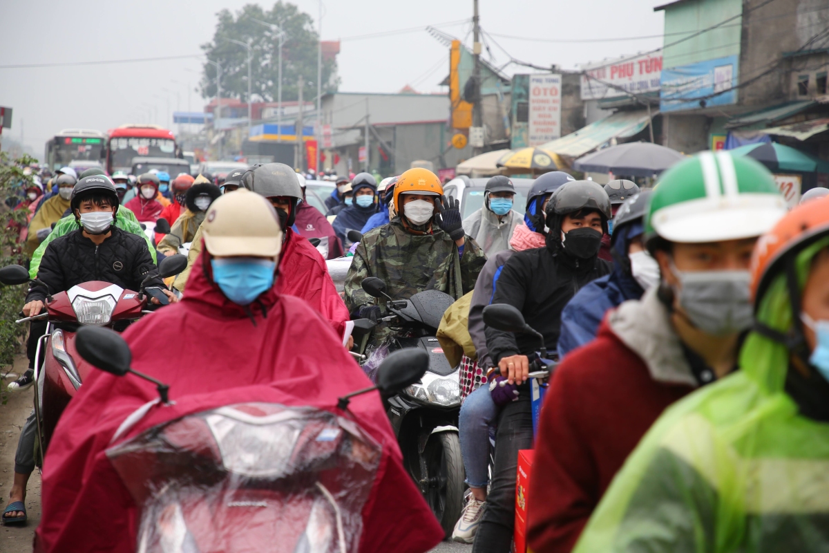 Người dân đội mưa rời Hà Nội về quê ăn Tết - Ảnh 1.