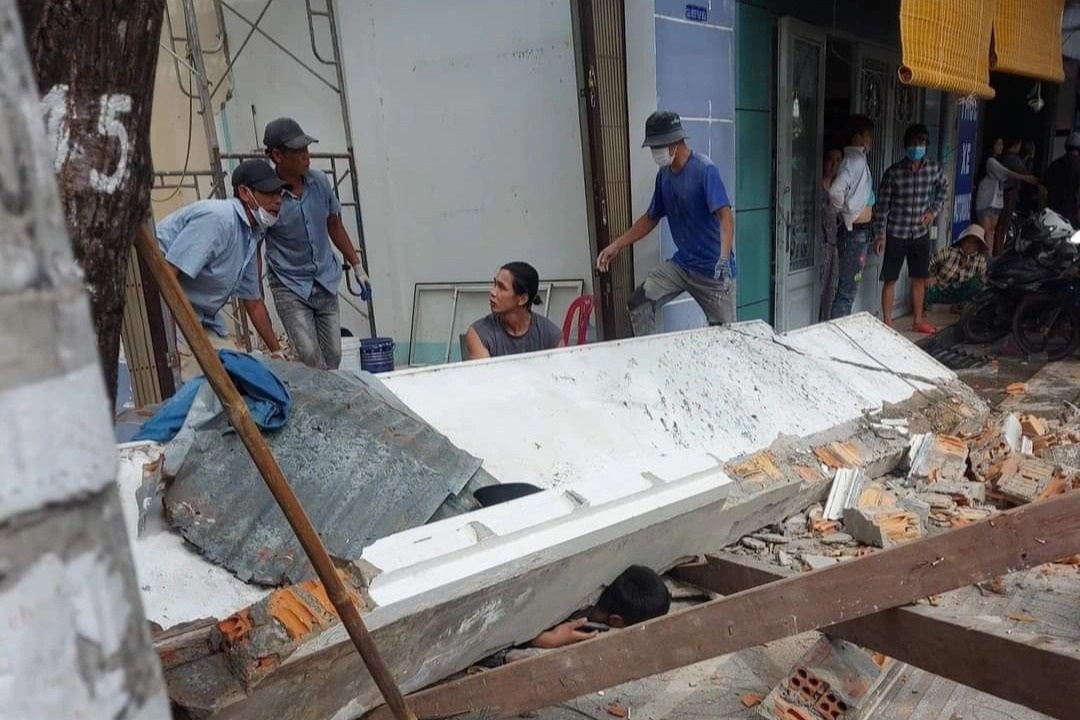 Tảng b&ecirc; t&ocirc;ng bất ngờ đổ sập, 2 người đang ngồi trước cửa nh&agrave; bị thương vong - Ảnh 1.