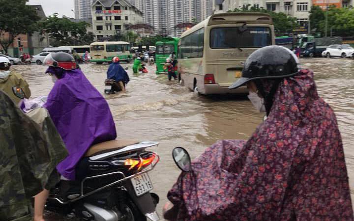 Mưa lớn kéo dài cả đêm, người dân Hà Nội đi làm trong 'biển nước'