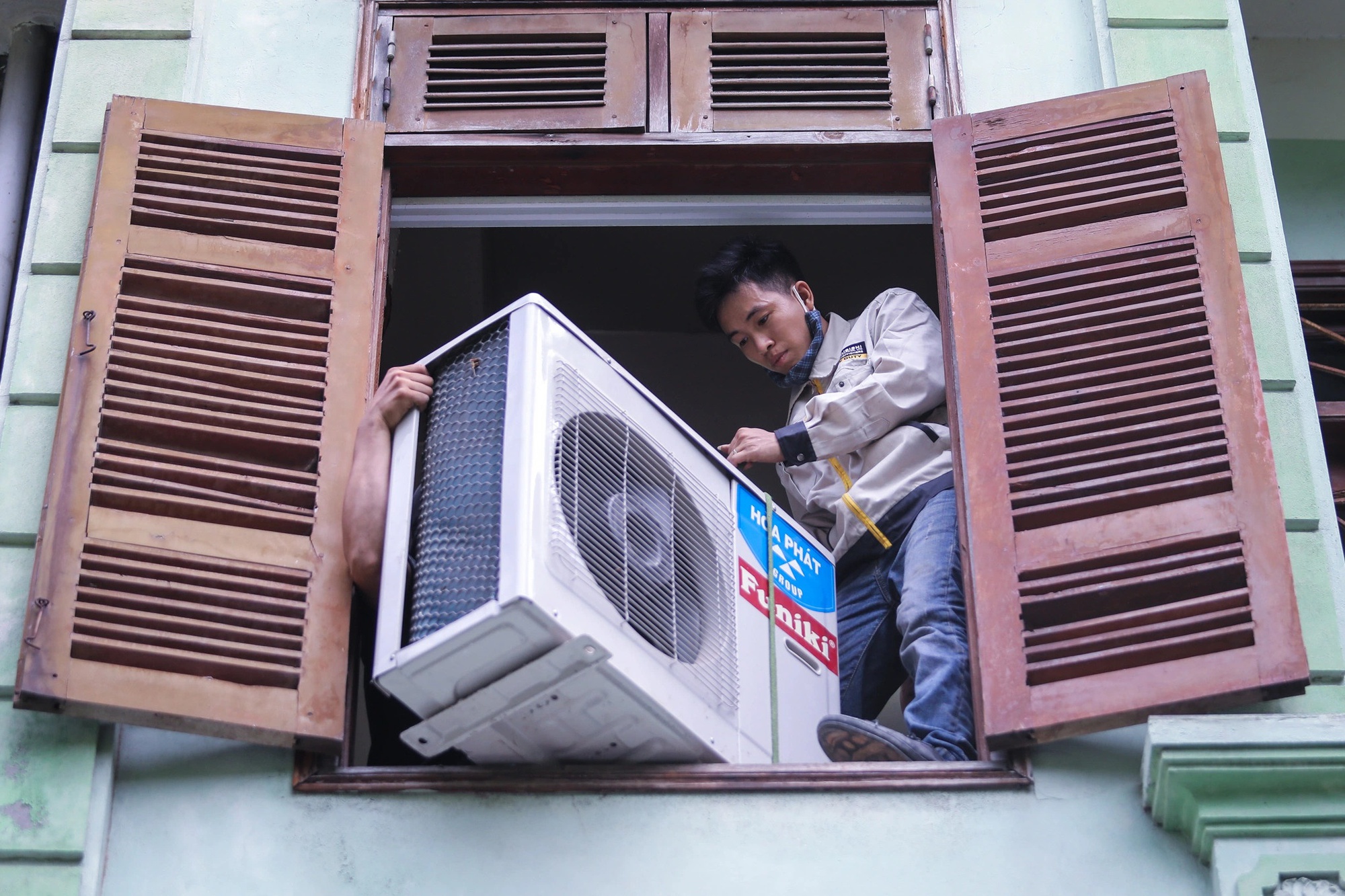 Vào mùa nóng, thợ sửa máy lạnh ở TP.HCM kiếm 100 triệu/tháng - Ảnh 2.