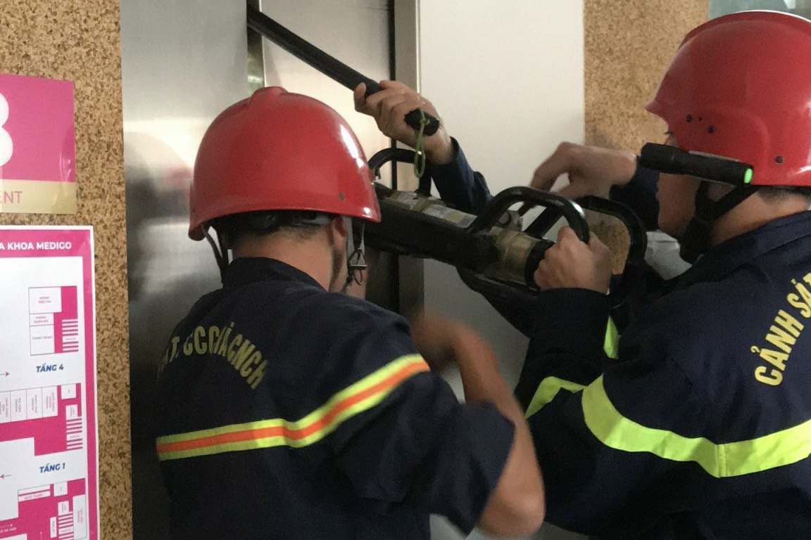 CLIP: Phá thang máy đưa 9 người mắc kẹt ra ngoài ở TP HCM - Ảnh 1.