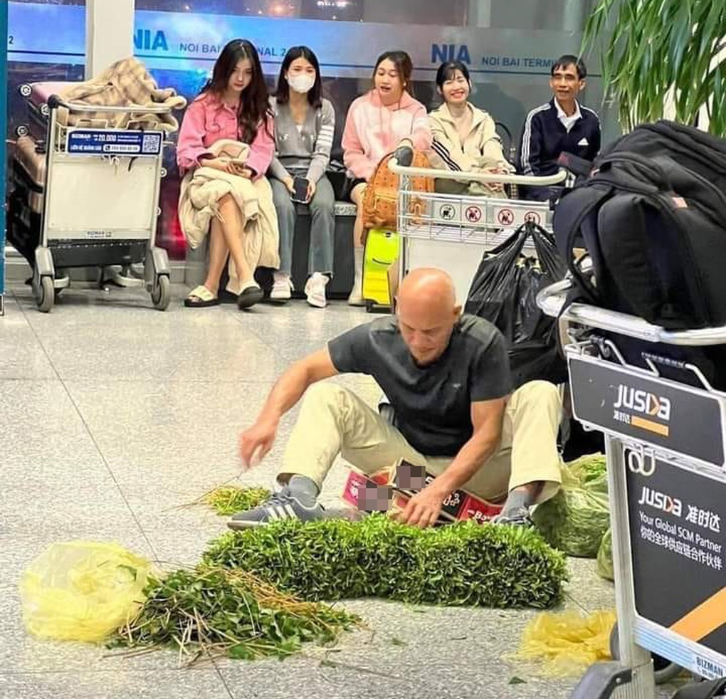 Khách tây ngồi nhặt rau muống tại sân bay Nội Bài - Ảnh 1.