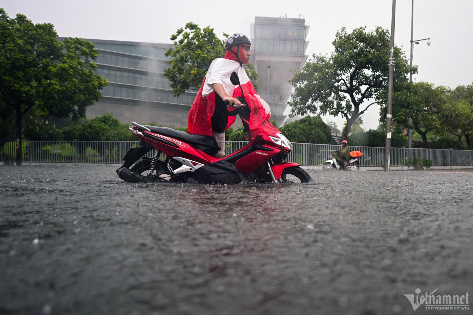 Hà Nội mưa lớn, người đi xe máy chới với giữa dòng nước ngập - Ảnh 1.