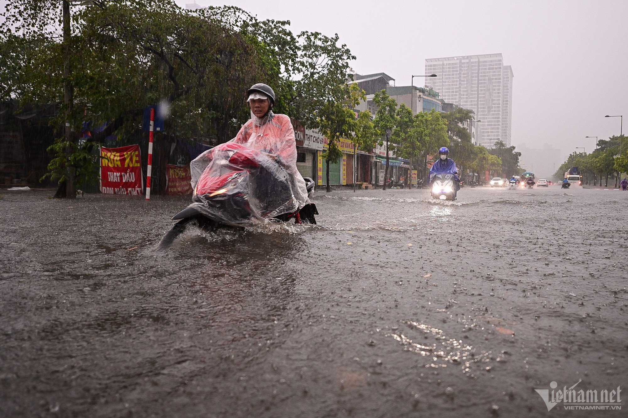 Hà Nội mưa lớn, người đi xe máy chới với giữa dòng nước ngập - Ảnh 2.