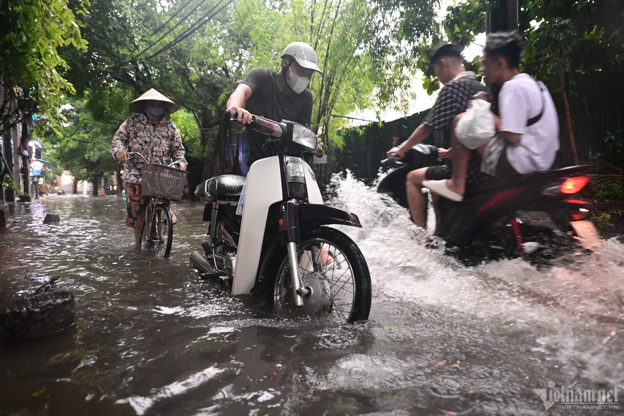 Hà Nội mưa lớn, người đi xe máy chới với giữa dòng nước ngập - Ảnh 3.