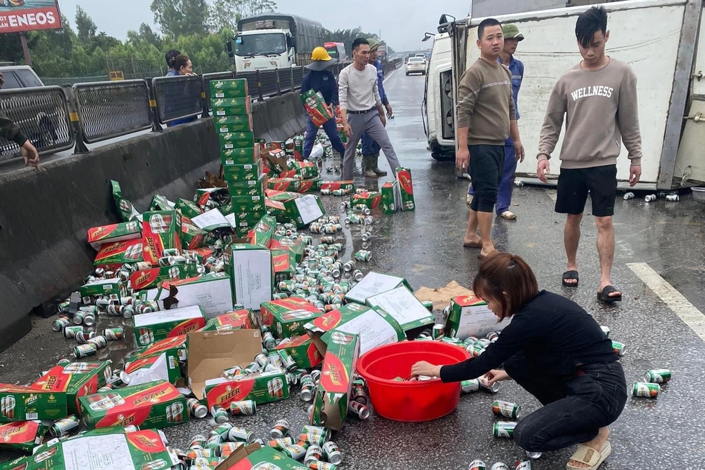 Người dân Nghệ An giúp tài xế gom hàng trăm thùng bia đổ tràn đường - Ảnh 1.