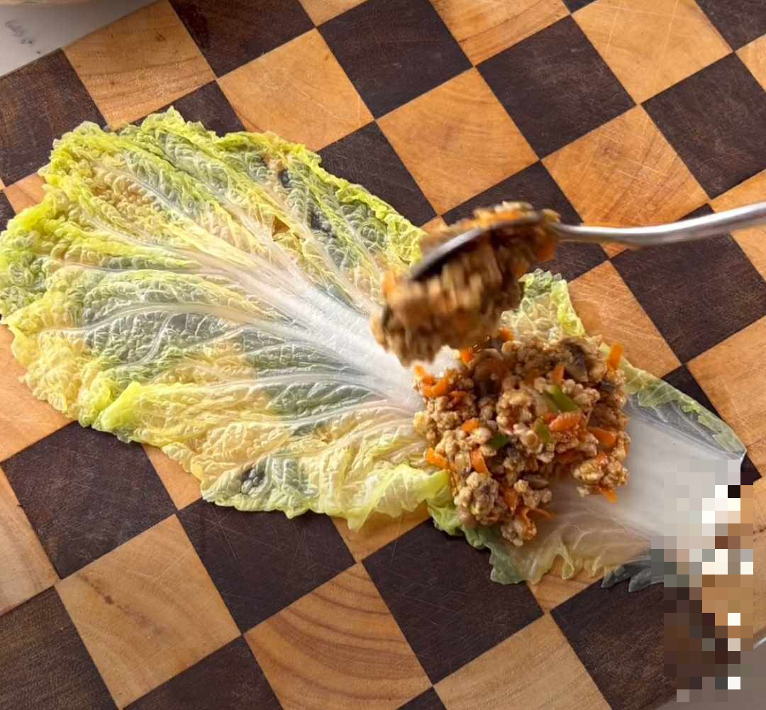 A spoon over a leaf of lettuce  Description automatically generated