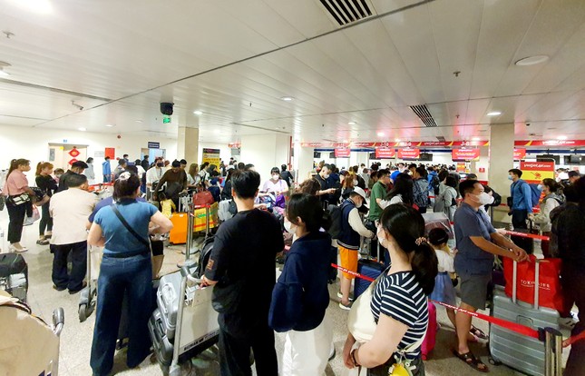 Sân bay Tân Sơn Nhất đông nghịt, khách vật vã từ mờ sáng 27 Tết - Ảnh 2.