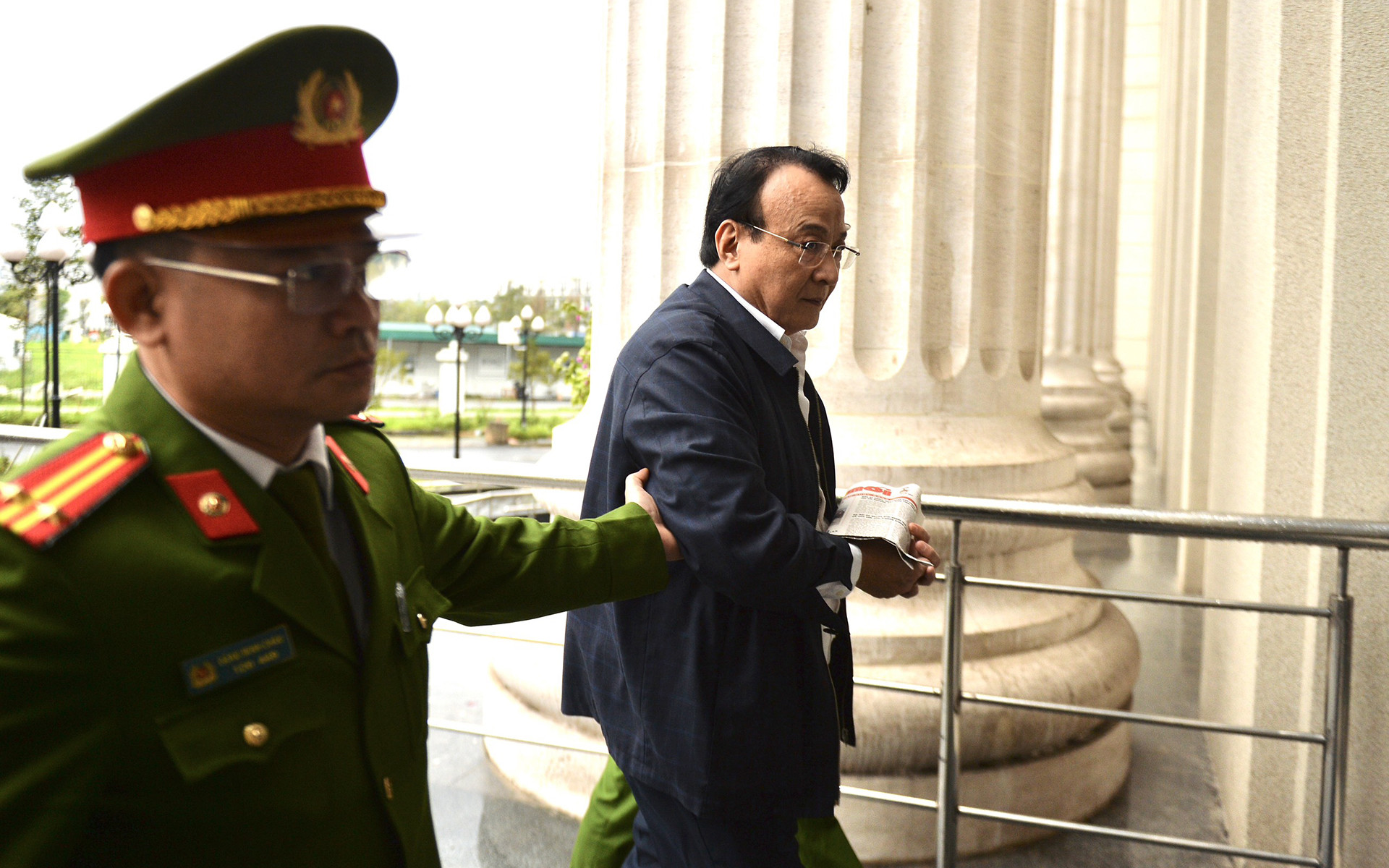 Chủ tịch Tân Hoàng Minh được dẫn tới tòa, hàng nghìn nhà đầu tư cùng đội mưa đến tham gia phiên xét xử