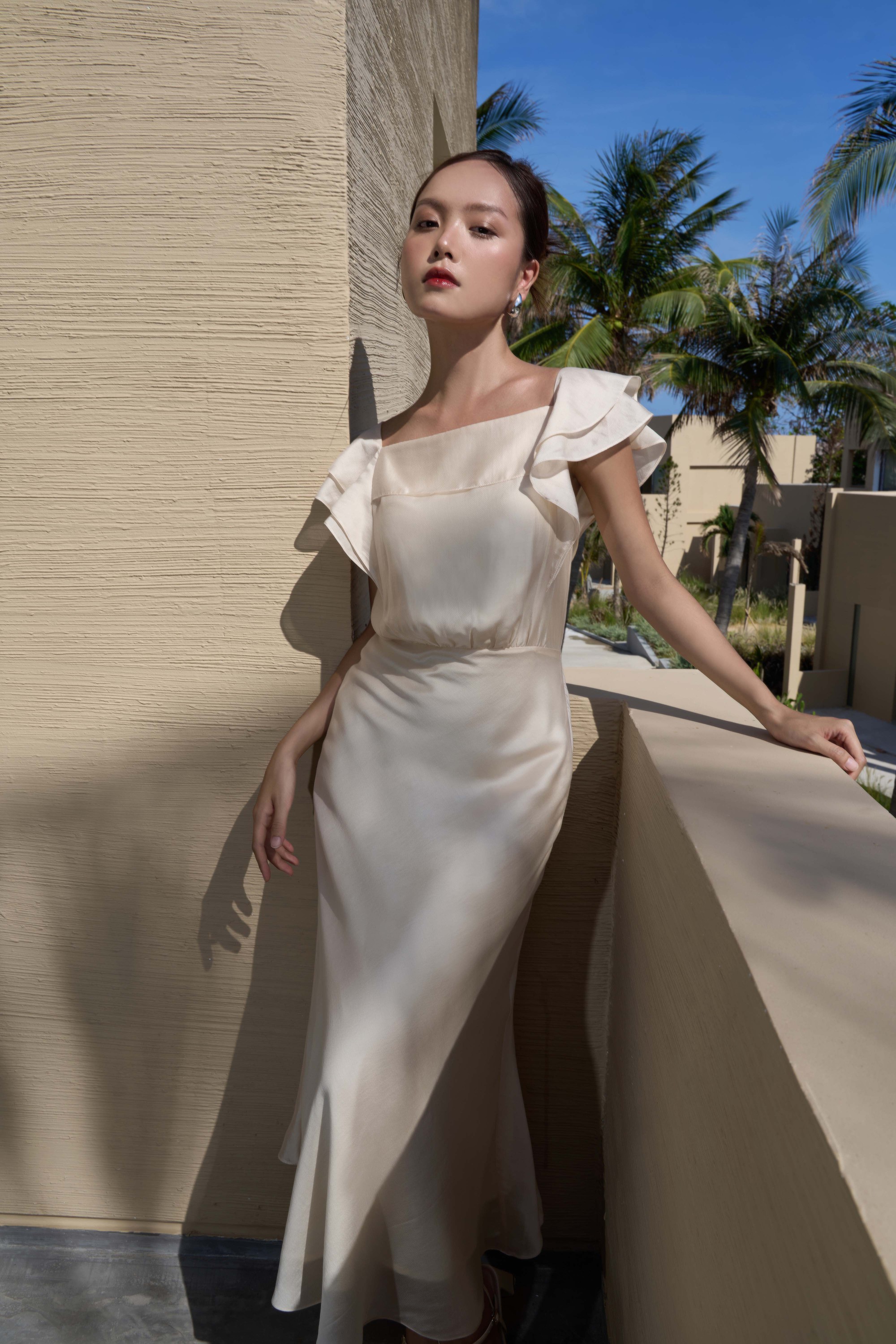 Mẫu váy lụa satin trắng là một thiết kế vừa phù hợp với công sở vừa hướng đến những chuyến du lịch. Thiết kế làm nổi bật phần thân trên của người mặc bằng chi tiết cổ vuông, tay cánh tiên xếp tầng bay bổng